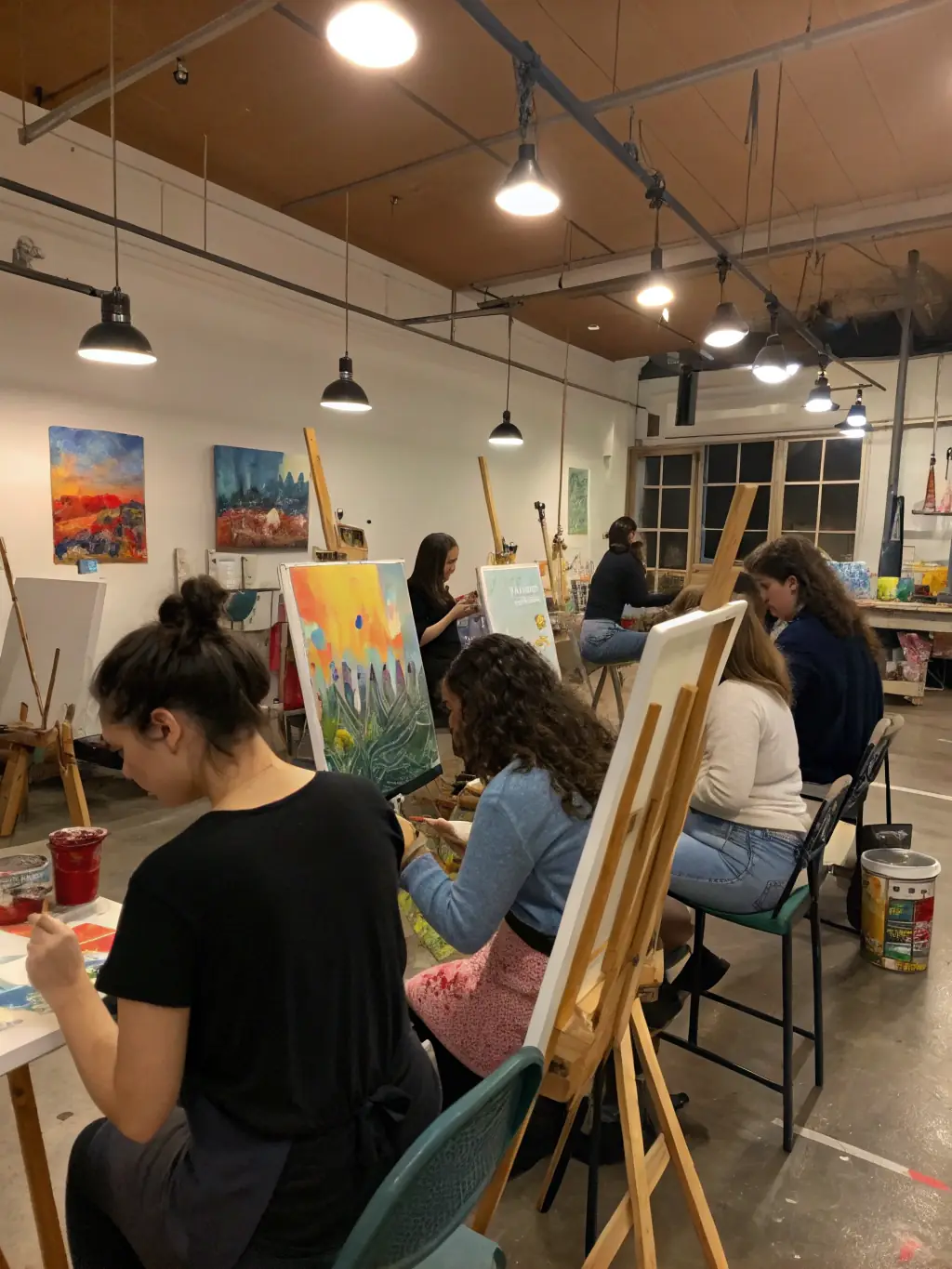A vibrant image of young participants engaged in a painting workshop, with colorful canvases and smiling faces, showcasing the Cultural and Artistic Workshops.
